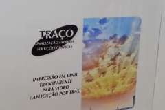 Adesivo transparente. Impressão por trás. Fundo claro.